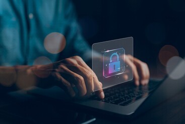 Hands typing on laptop keyboard overlaid with padlock icon