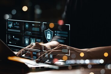 hands on a keyboard with icons representing AI and cybersecurity overlaid on top