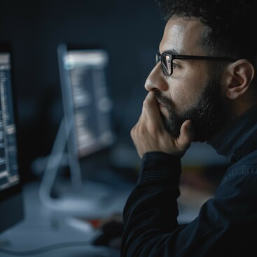 Man wearing glasses looking at screen