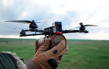 Hand in a glove holding a small drone